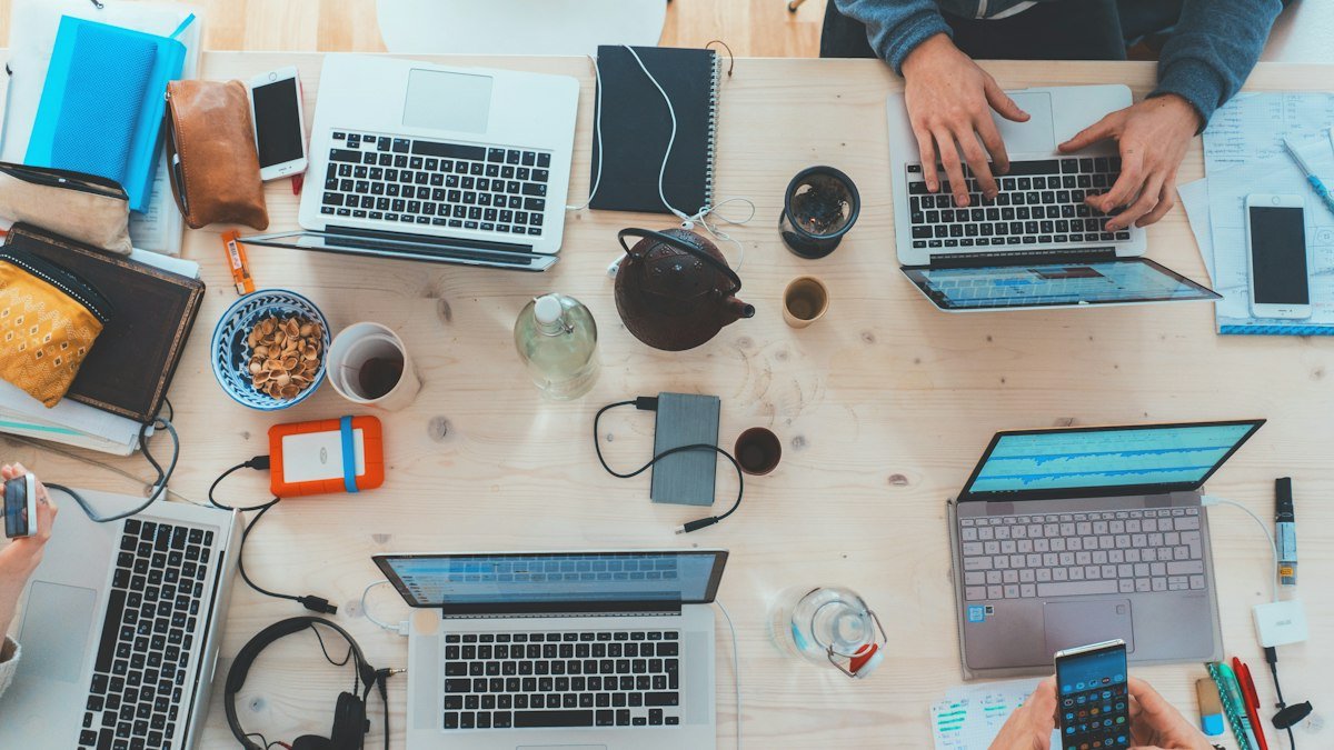 Photo by Marvin Meyer on Unsplash. Source: https://unsplash.com/photos/people-sitting-down-near-table-with-assorted-laptop-computers-SYTO3xs06fU (Unsplash License).