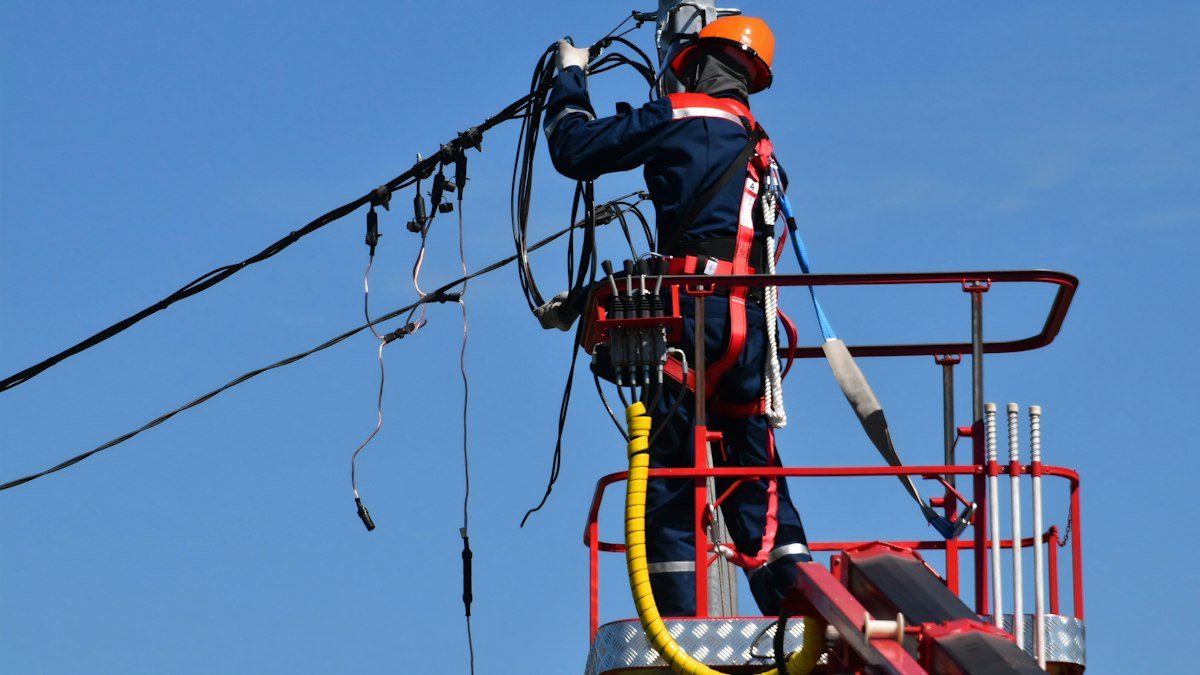 Photo by Антон Дмитриев on Unsplash. Source: https://unsplash.com/photos/utility-worker-repairing-overhead-power-lines-Q3WVbAfdOoY (Unsplash License).