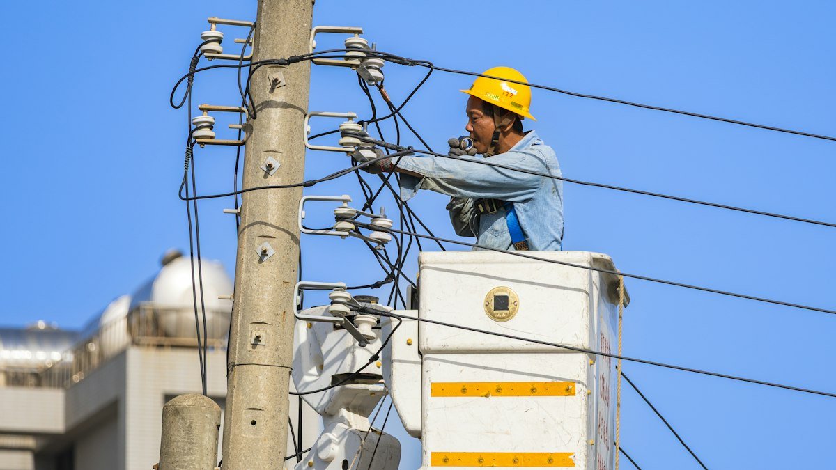 Photo by EriGle Gon on Unsplash. Source: https://unsplash.com/photos/an-electrician-works-on-power-lines-from-a-lift-QBeTa2KoTyI (Unsplash License).