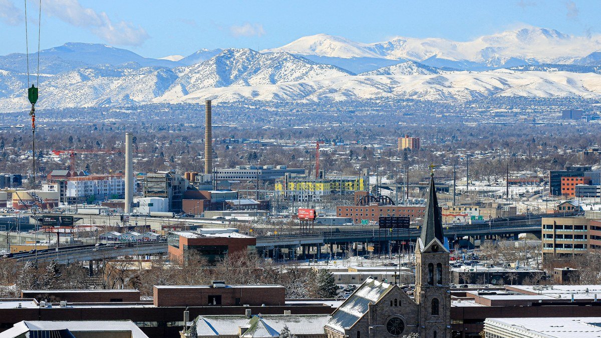 The Denver skyline with the snow covered Front Range rising behind it. Tech Thought Leaders is based in Denver, Colorado.