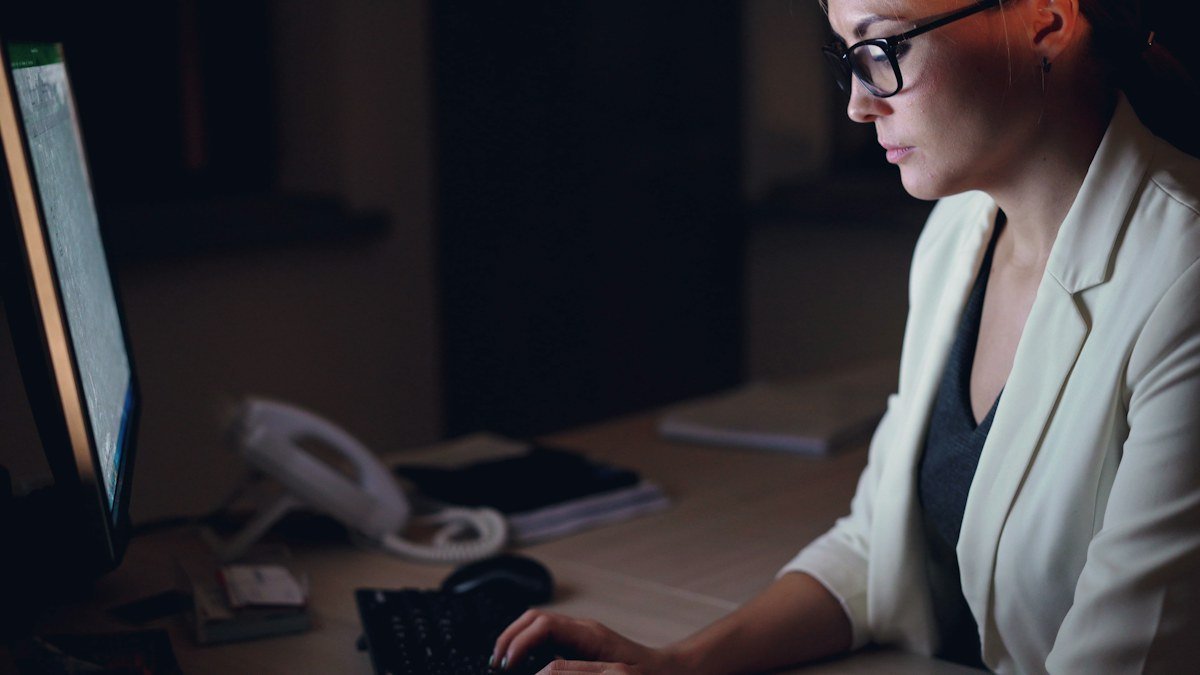 Photo by Vitaly Gariev on Unsplash. Source: https://unsplash.com/photos/woman-working-on-computer-at-night-qLypTcjzTmA (Unsplash License). A woman working at a computer at night, illustrating an after-hours security incident response.