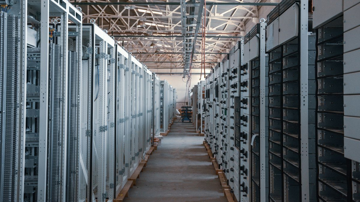 Photo by İsmail Enes Ayhan on Unsplash. Source: https://unsplash.com/photos/server-room-aisle-with-metal-equipment-racks-lVZjvw-u9V8 (Unsplash License).