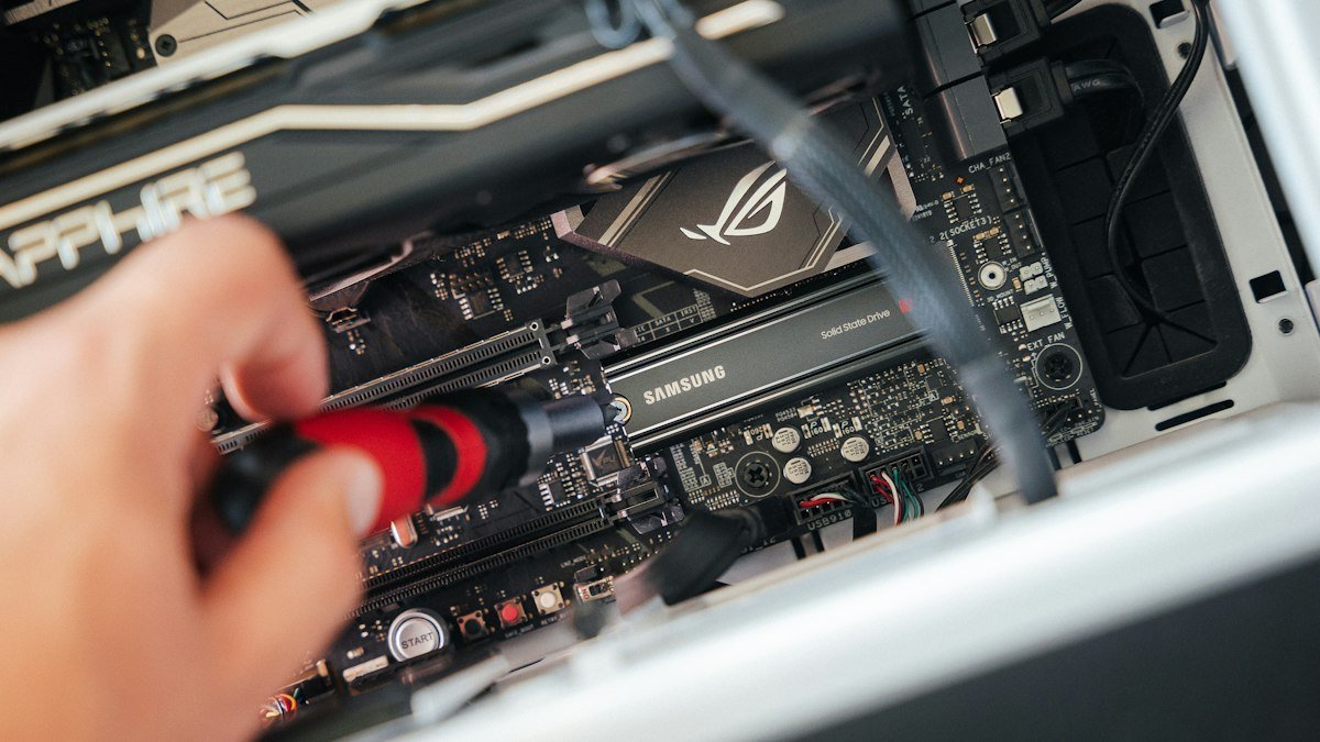 A person installing a graphics card on a computer. Photo by Samsung Memory on Unsplash. Source: https://unsplash.com/photos/a-person-holding-a-device-iRY8lnq0xb0 (Unsplash License).