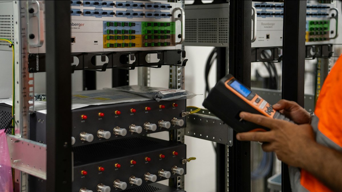 Photo by Valentin Lacoste on Unsplash. Source: https://unsplash.com/photos/technician-inspecting-server-racks-with-a-handheld-diagnostic-tool-A-b2nPSSK6E (Unsplash License).