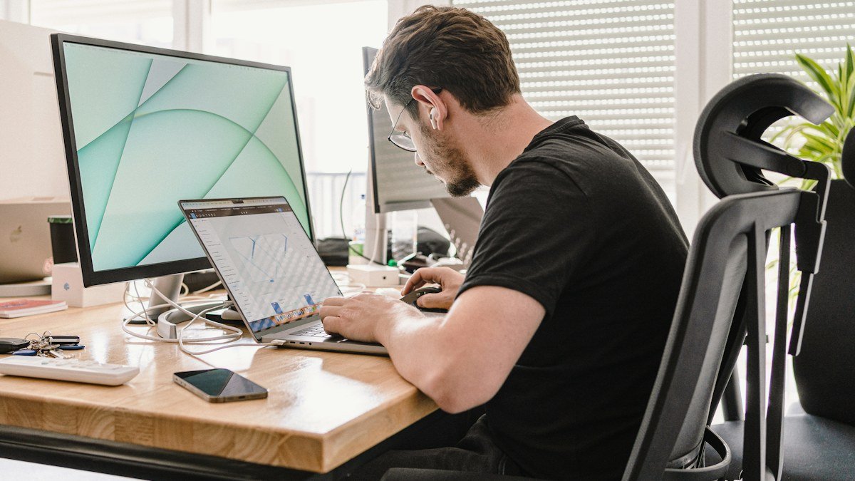 Photo by Azwedo L.LC on Unsplash. Source: https://unsplash.com/photos/a-man-sitting-at-a-desk-working-on-a-computer-g4c1wNljbBI (Unsplash License).