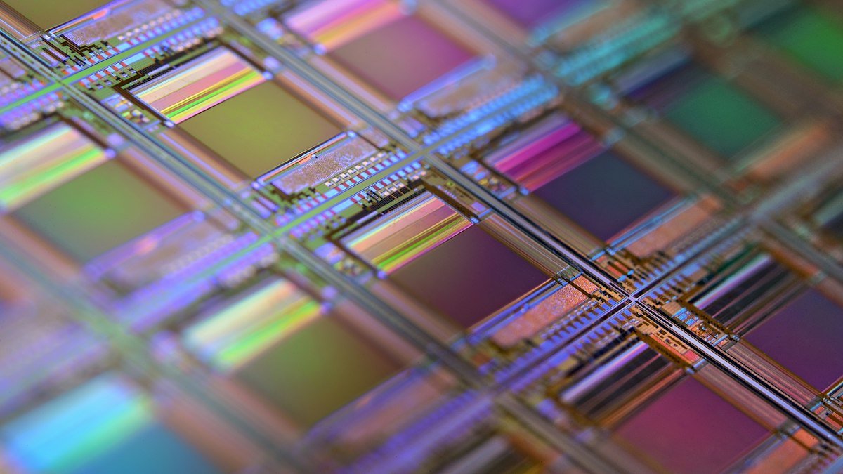 Photo by Laura Ockel on Unsplash. Source: https://unsplash.com/photos/a-silicon-wafer-with-a-grid-of-iridescent-microchip-dies-under-shallow-focus-bad89242c735 (Unsplash License).