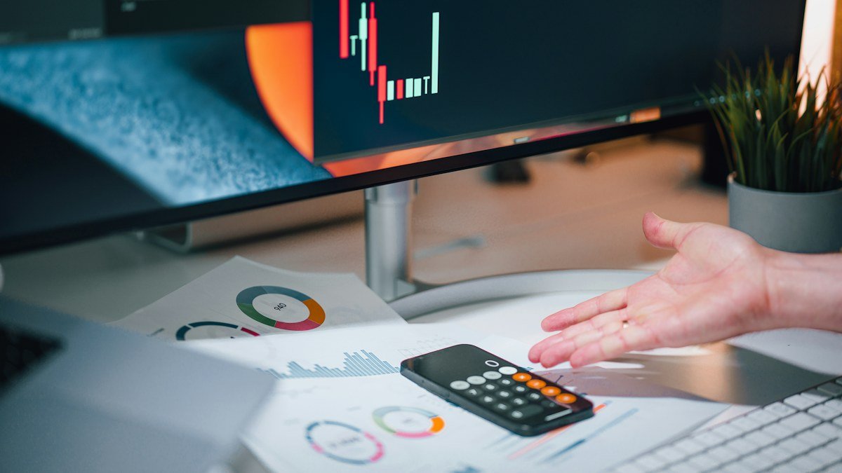 Photo by Jakub Żerdzicki on Unsplash. Source: https://unsplash.com/photos/a-person-pointing-at-a-calculator-on-a-desk-eGI0aGwuE-A (Unsplash License).