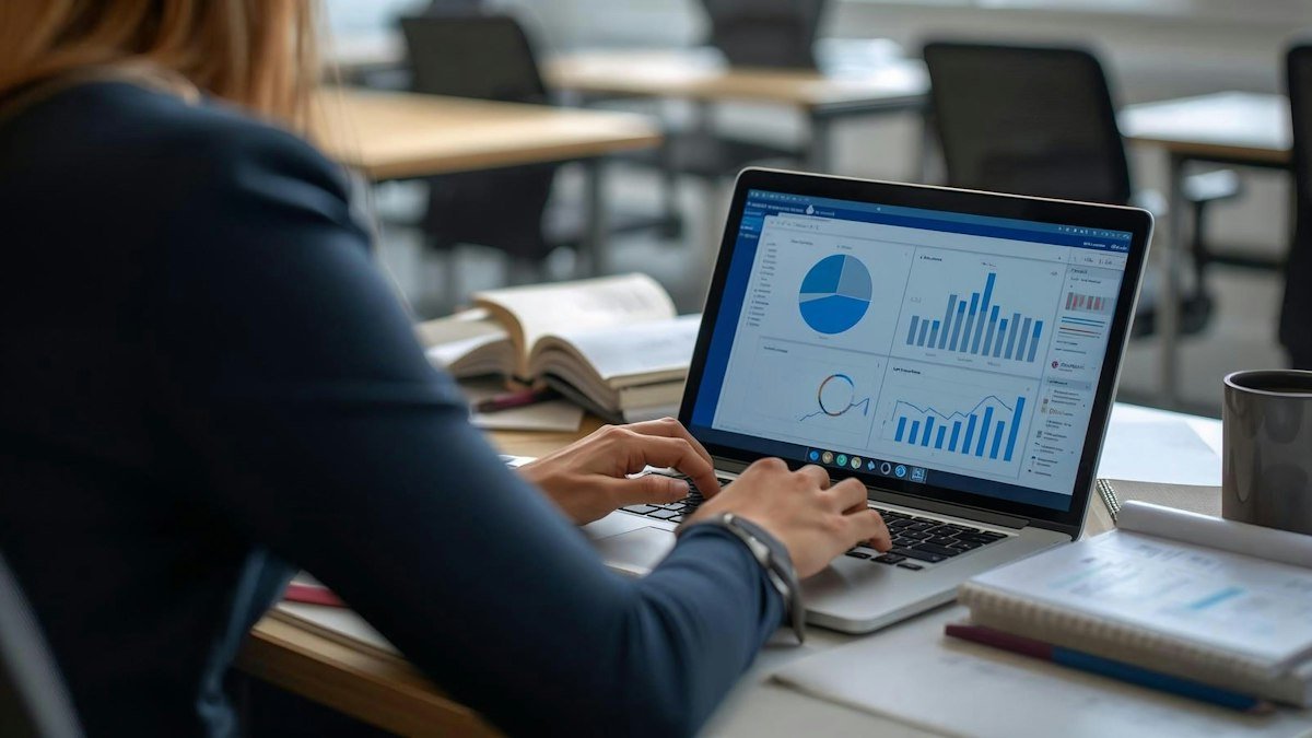 Photo by Apex Virtual Education on Unsplash. Source: https://unsplash.com/photos/woman-working-on-laptop-with-charts-and-graphs-KNQUEQwTCY4 (Unsplash License).