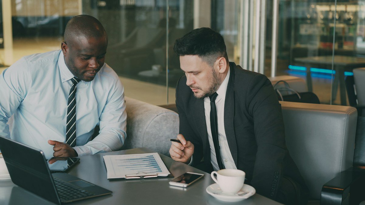 Photo by Vitaly Gariev on Unsplash. Source: https://unsplash.com/photos/two-businessmen-reviewing-documents-at-a-table-Kul6JqIDA3I (Unsplash License).