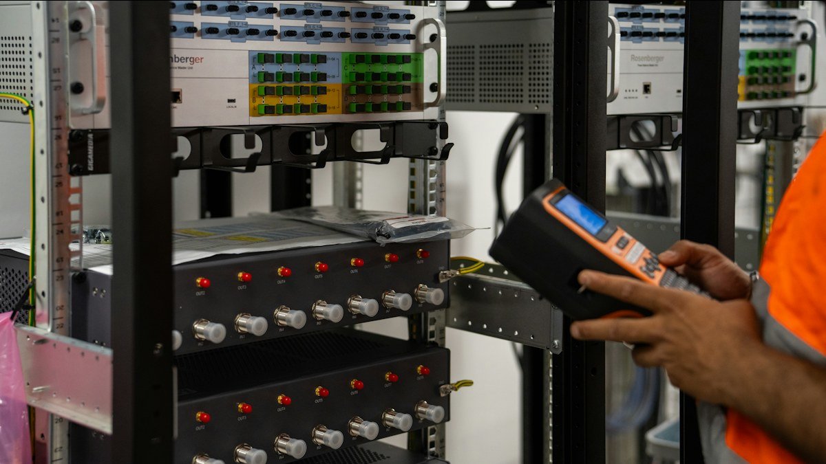 Photo by Valentin Lacoste on Unsplash. Source: https://unsplash.com/photos/technician-inspecting-server-racks-with-a-handheld-diagnostic-tool-A-b2nPSSK6E (Unsplash License).