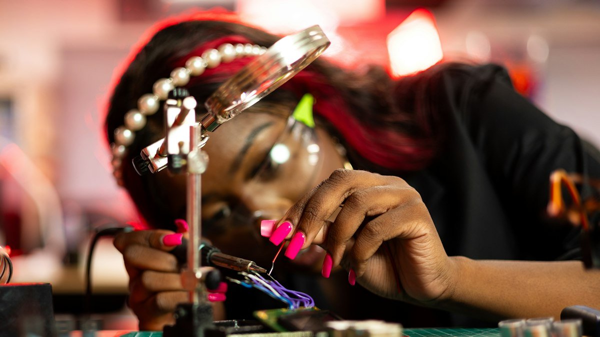 Photo by ThisisEngineering on Unsplash. Source: https://unsplash.com/photos/a-woman-working-on-a-circuit-board-with-a-magnifying-glass-lAbYmLWrT9o (Unsplash License).