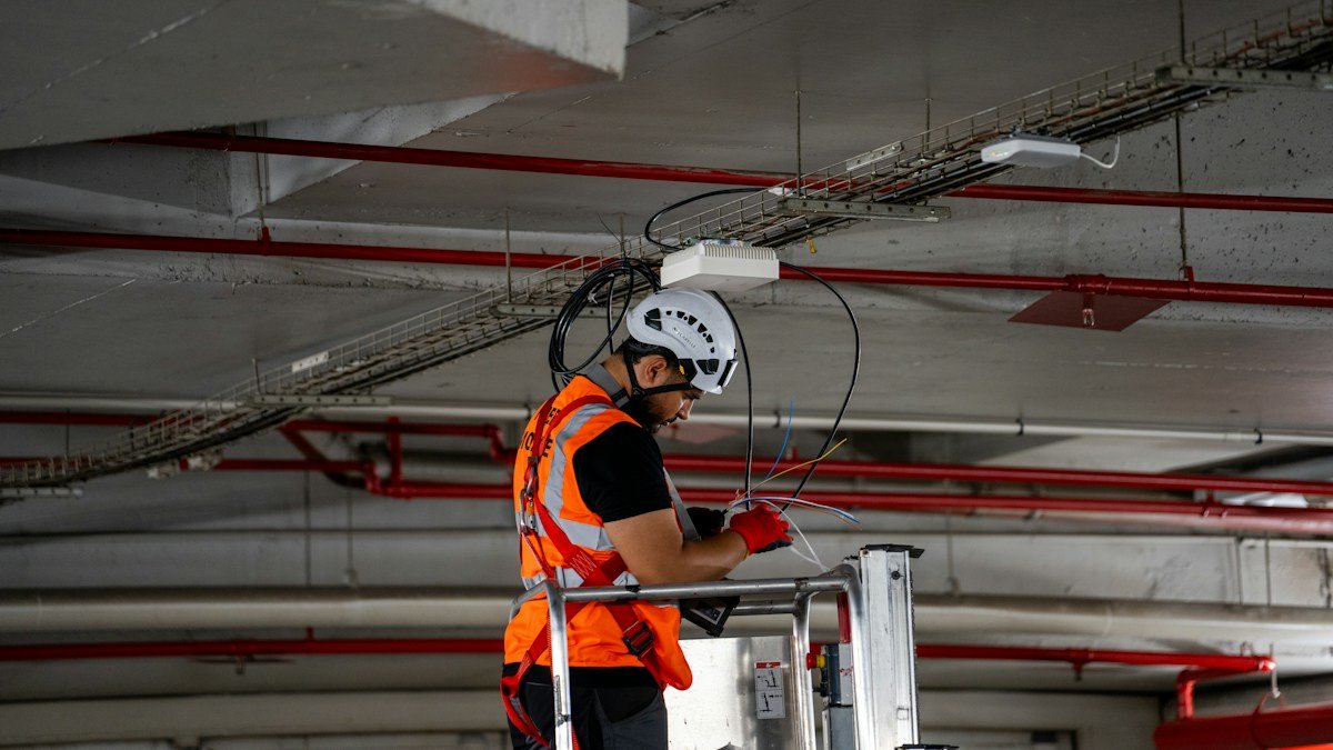Photo by Valentin Lacoste on Unsplash. Source: https://unsplash.com/photos/man-in-safety-vest-working-on-ceiling-infrastructure-uPUPJEck3qE (Unsplash License).