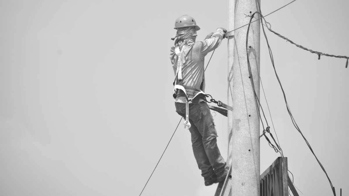 Photo by john philip olegario on Unsplash. Source: https://unsplash.com/photos/lineman-working-on-a-utility-pole-with-safety-harness-58jThUYbYJY (Unsplash License).
