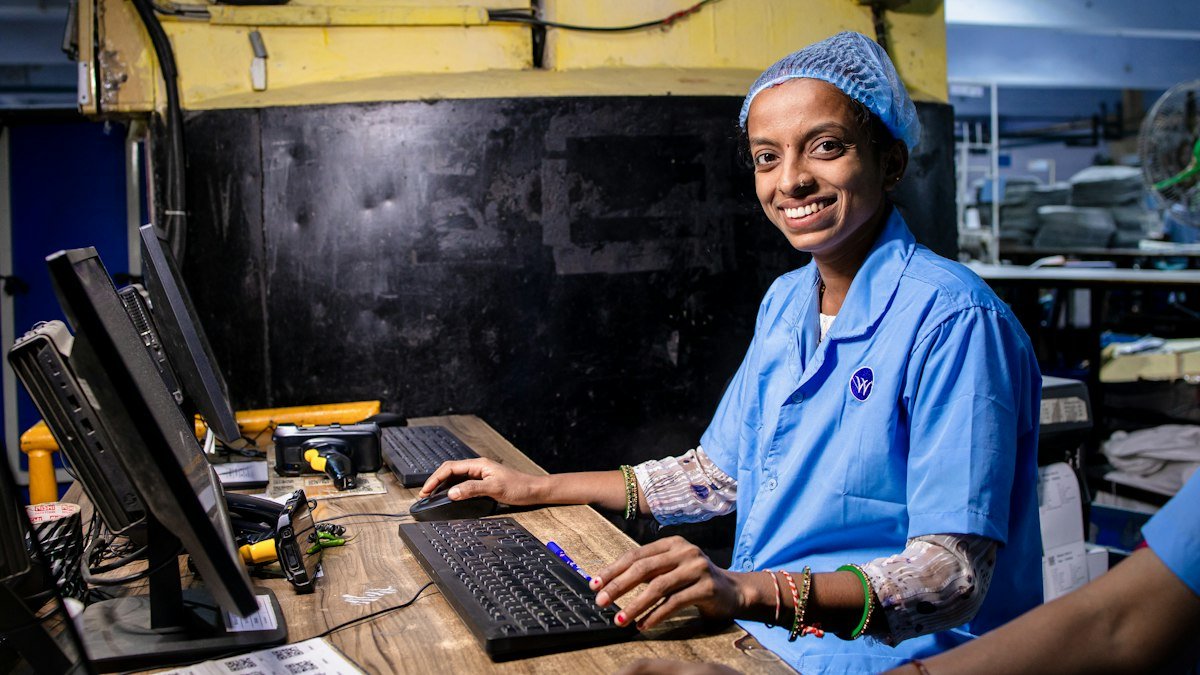 An operator works at a computer workstation on a production floor. Photo by EqualStock on Unsplash. Source: https://unsplash.com/photos/utiENK_NPeA (Unsplash License).