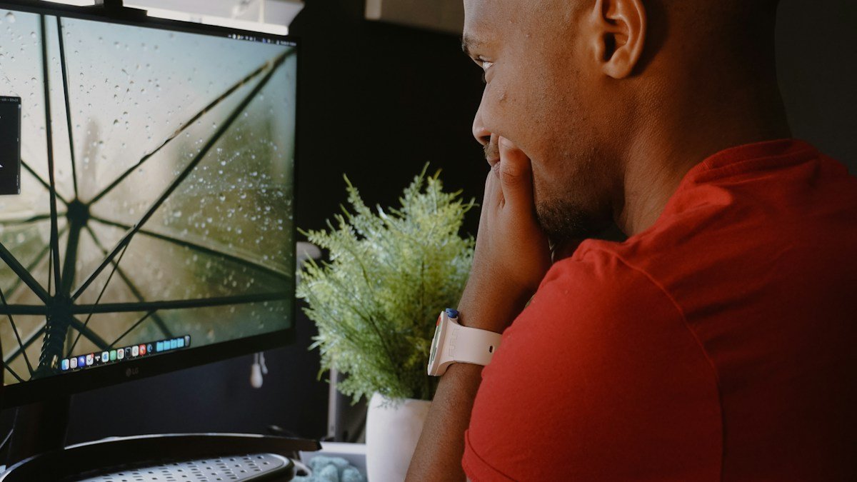 Photo by Terrillo Walls on Unsplash. Source: https://unsplash.com/photos/a-man-sitting-in-front-of-a-computer-monitor-MJUvXbVZwjs (Unsplash License).