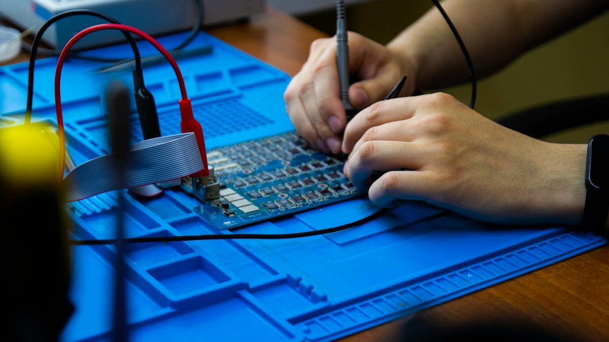 Photo by Igor Gramadchukov on Unsplash. Source: https://unsplash.com/photos/a-person-working-on-a-circuit-board-9nKLWw45B3I (Unsplash License).