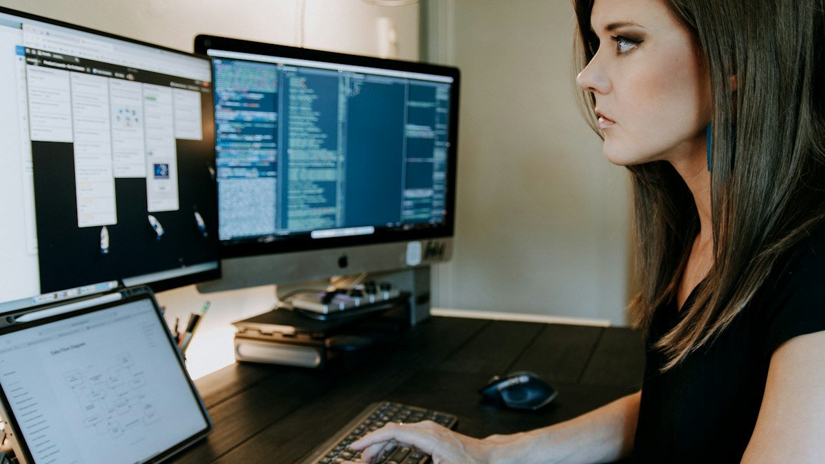Photo by Kelly Sikkema on Unsplash. Source: https://unsplash.com/photos/a-woman-sitting-at-a-desk-using-a-computer-A3XL3jDki70 (Unsplash License).