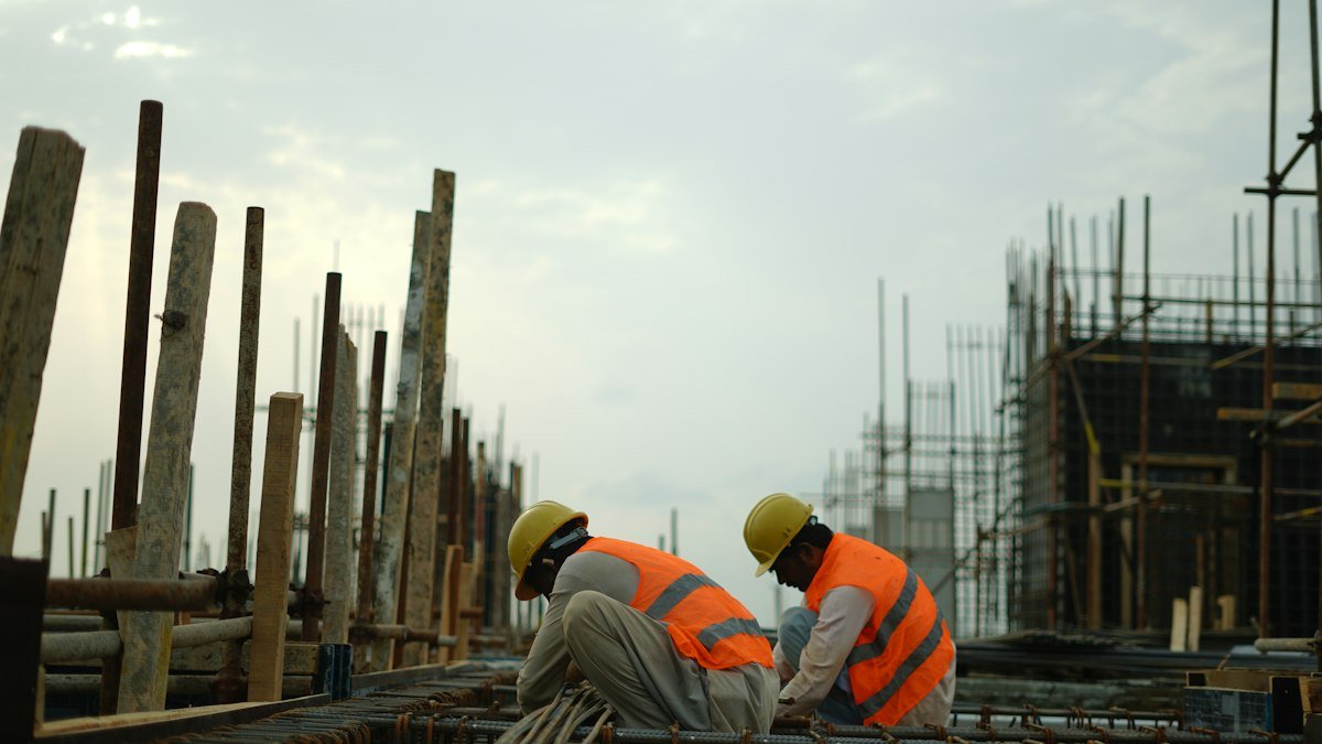 Photo by Wasif Ali on Unsplash. Source: https://unsplash.com/photos/construction-workers-in-hard-hats-and-safety-vests-on-site-fBtNXtM4o3k (Unsplash License).