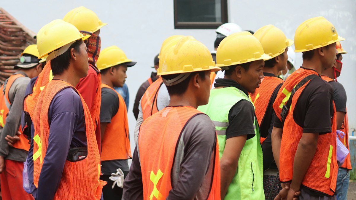 Photo by Mufid Majnun on Unsplash. Source: https://unsplash.com/photos/man-in-orange-vest-wearing-yellow-hard-hat-7TR0TGS7zqg (Unsplash License).
