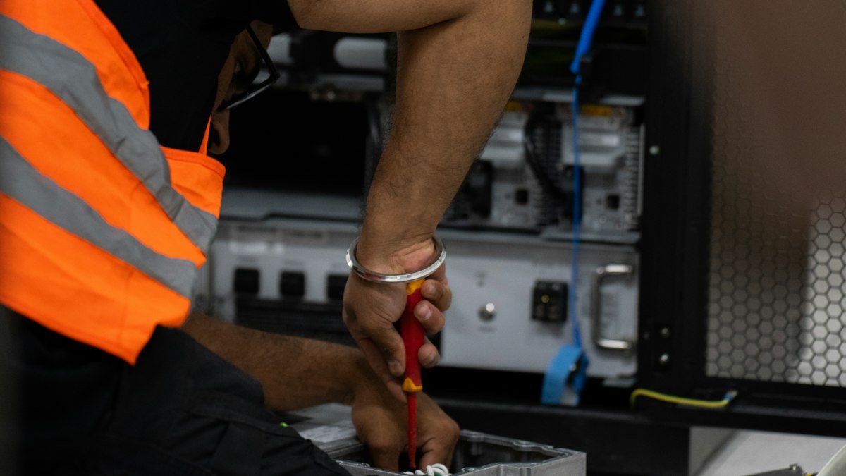 Photo by Valentin Lacoste on Unsplash. Source: https://unsplash.com/photos/technician-working-on-network-equipment-with-tools-fJTyegEd-6k (Unsplash License).
