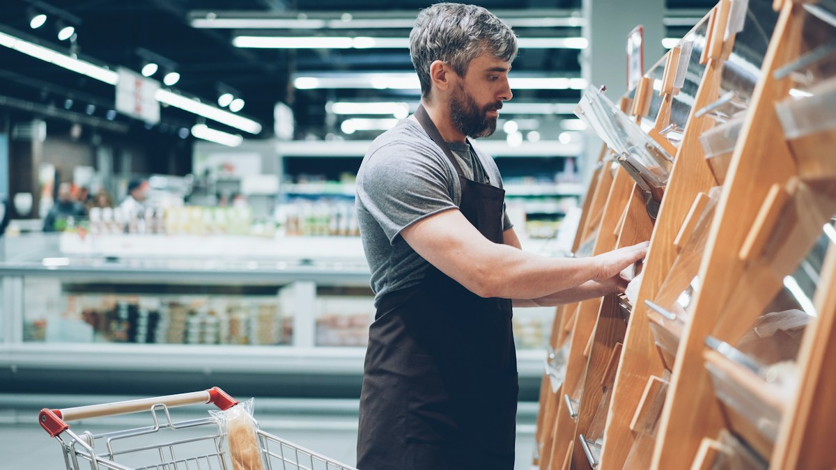 Photo by Vitaly Gariev on Unsplash. Source: https://unsplash.com/photos/a-man-sorts-items-in-a-grocery-store-YJxMAewMsLU (Unsplash License).