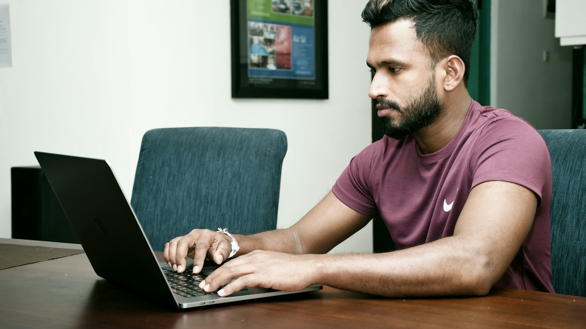 An engineer works at a laptop in a warm lit office. Photo by Kelum Chathuranga on Unsplash. Source: https://unsplash.com/photos/a-man-sitting-in-front-of-a-laptop-computer-0m-6I48ChD8 (Unsplash License).